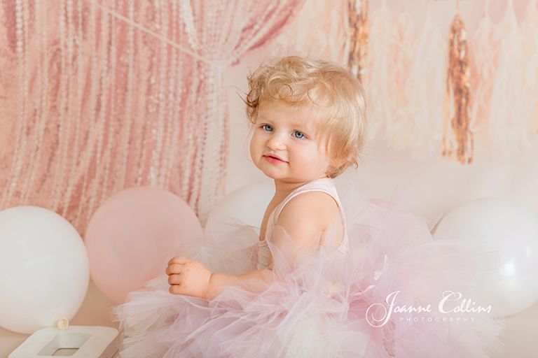 lovely smiley face during first year birthday photoshoot, wearing pink tutu