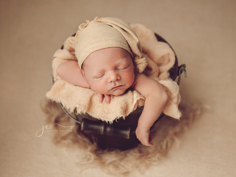 2 Day Camera and Newborn Photography Training Course. Beautiful baby boy posing safely in a bucket with a cute yellow sleepy hat