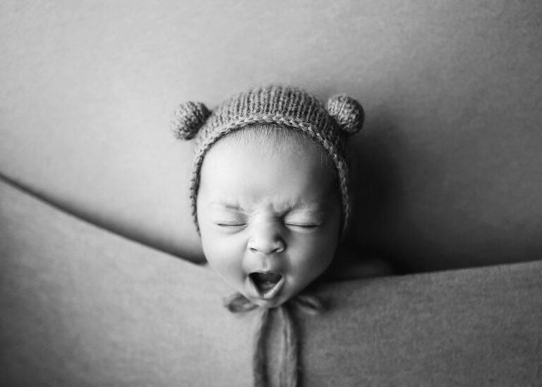 Newborn Photography Training and baby safety and bab y is yawning with a teddy bonnet on